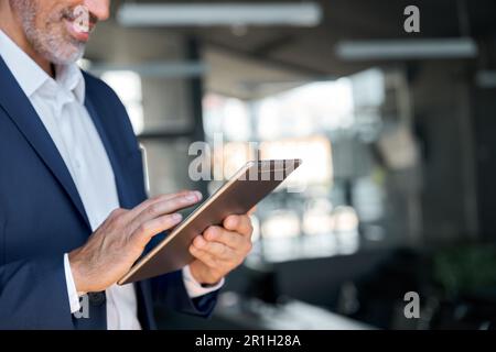 Happy middle aged business man executive in office using digital tablet. Closeup Stock Photo