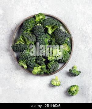 fresh broccoli vegetables in a gray plate on a light gray background top view Stock Photo