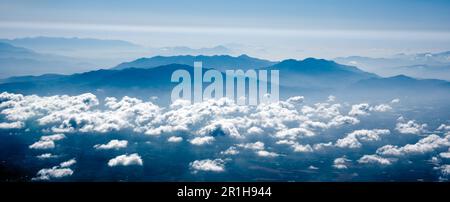 Panoramic view of mountains above small clouds Stock Photo