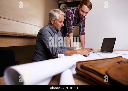 Architects, teamwork and men with blueprint in workshop for building construction. Senior engineer, father and son working on design, project and Stock Photo