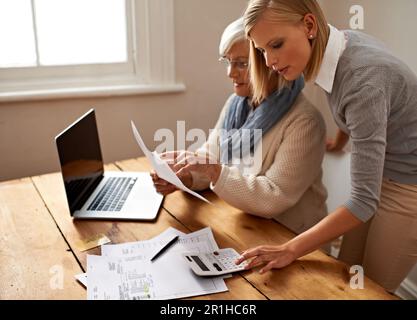Calculator, senior mother and daughter helping for taxes or laptop or table for bills and money at home. Retirement, budget and old woman or pension Stock Photo