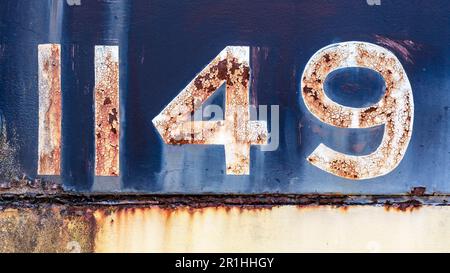 Grunge worn rusty metal background with chipped and faded painted numbers Stock Photo