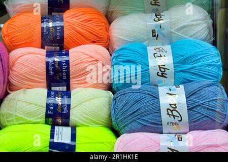 fashion double knitting balls of wool in shop window photographed from the street Stock Photo