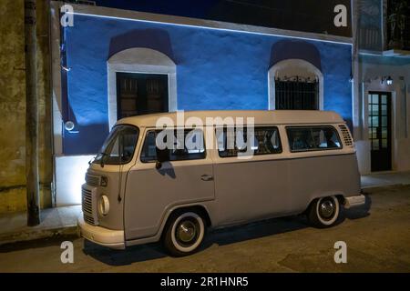 old restored VW bus in front of a blue painted house at night in the Santiago district in Merida Yucatan Mexico Stock Photo