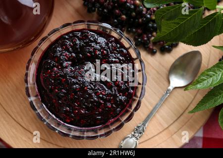 Elderberry jam with Sambucus berries on table, flat lay Stock Photo