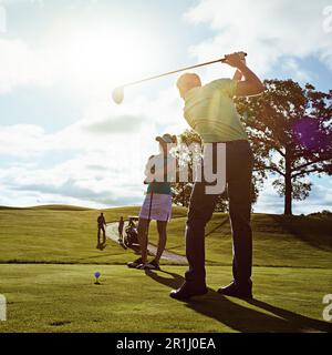 He just keeps getting better anf better. a couple playing golf together on a fairway. Stock Photo