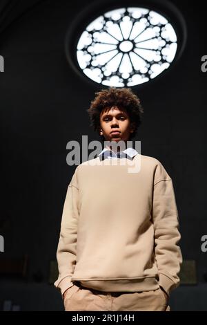 Vertical image of African American boy looking at camera while standing in baptist church Stock Photo