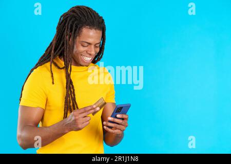 Happy latin man using mobile and card to shopping online Stock Photo