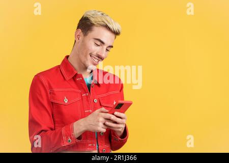 Happy gay man smiling while using the mobile Stock Photo