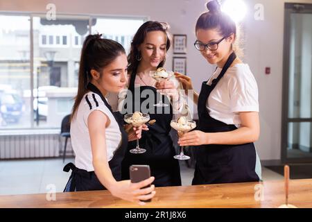 Fenale students in cookery class taking selfie after cooking - friends and social media concept Stock Photo