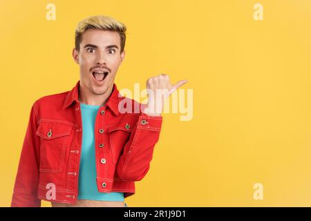 Surprised gay man pointing a blank space aside Stock Photo