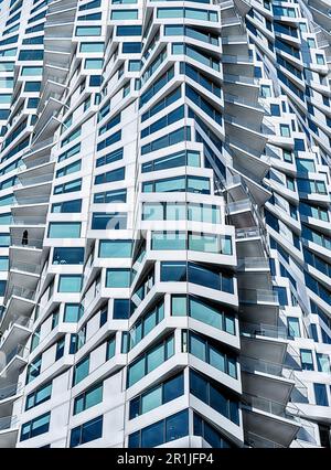 The  spiral exterior design of a modern apartment building results in a complex background of light and shadow. Stock Photo