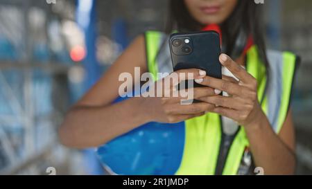 African american woman builder using smartphone at street Stock Photo