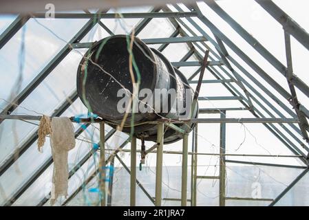 The water tank in the greenhouse is used to water the plants. Garden, rural, cottage. Stock Photo