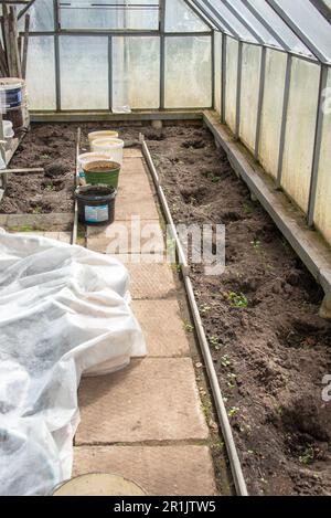 View of interior of greenhouse prepared for planting vegetables in early spring. Garden, rural, cottage. Stock Photo