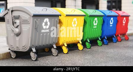 Garbage containers with separated garbage on a street. Trash bins for plastic, glass, paper and organic. Segregate waste and garbage recycling concept Stock Photo