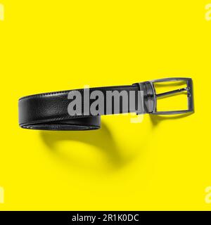 Top up up view black leather belt isolated on yellow background. suitable for your design project. Stock Photo