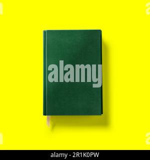 Back to school concept , hard cover dark green book front close isolated on yellow. Stock Photo