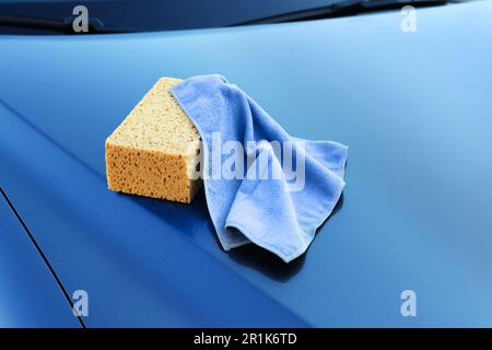 Sponge and rag on car hood outdoors. Cleaning products Stock Photo - Alamy