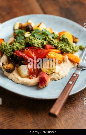 Roasted Root Vegetables on Butter Bean Hummus with Zhoug Stock Photo