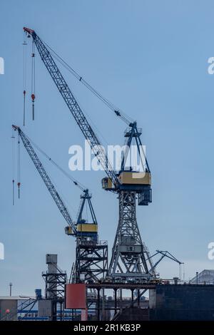 Hamburg, Germany - 04 17 2023: two cranes at a dock in the port of hamburg against a blue sky. Stock Photo