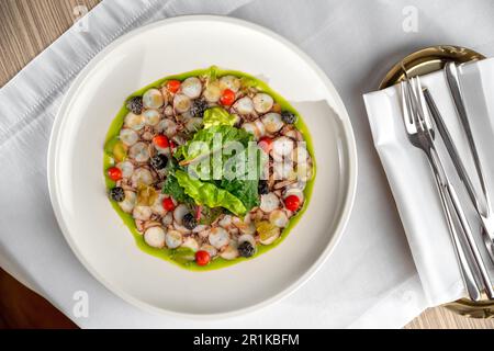 Seafood appetizer. Octopus Carpaccio on white plate. Mediterranean delicacy. Selective focus Stock Photo