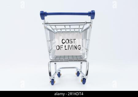 Business concept. On a white background is a shopping cart with a sign that says - Cost of living Stock Photo