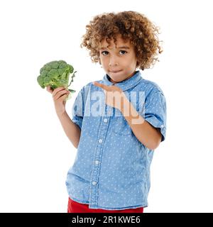 Ok, who shrunk this tree. Studio shot of a cute little boy pointing to broccoli against a white background. Stock Photo