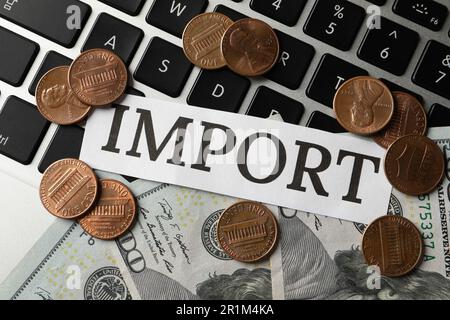 Card with word Import and money on laptop keyboard, flat lay Stock Photo