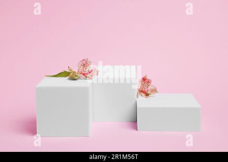 Scene for product presentation. Podiums of different geometric shapes and flowers on pink background Stock Photo