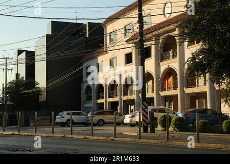 Many parked cars near building on sunny day Stock Photo