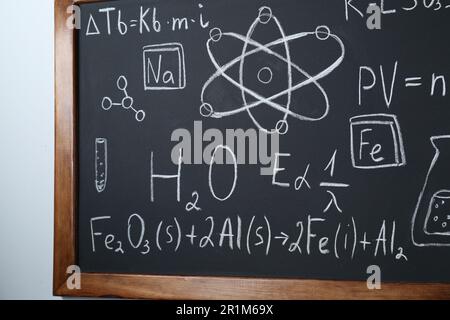 Blackboard with different mathematical formulas written in chalk on white wall Stock Photo