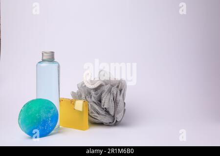 Grey shower puff and cosmetic products on white background, space for text Stock Photo