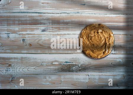 peanut butter on a plate with salted peanuts. paleo diet and keto diet food on wooden table. Stock Photo