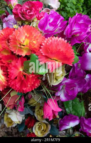 Artificial flowers on a grave in West Norwood Cemetery, one of London's 'Magnificent Seven' cemeteries, London, England, United Kingdom Stock Photo