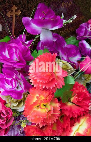 Artificial flowers on a grave in West Norwood Cemetery, one of London's 'Magnificent Seven' cemeteries, London, England, United Kingdom Stock Photo