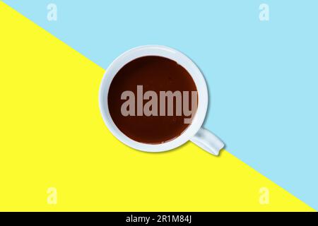 Hot chocolate milk on white ceramic mug isolated on colored background. Stock Photo