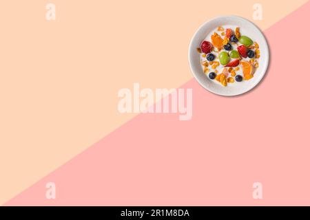 Close up view various fruits soup with milk isolated on pink background. Stock Photo