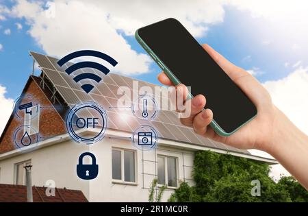Woman using phone application for controlling smart home outdoors, closeup Stock Photo