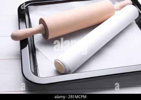 https://l450v.alamy.com/450v/2r1mcpm/baking-pan-with-parchment-paper-and-rolling-pin-on-white-wooden-table-closeup-2r1mcpm.jpg