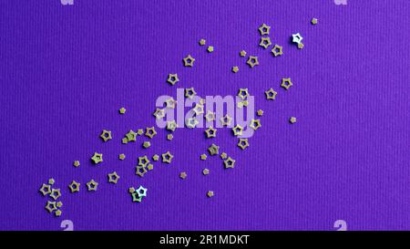 Many silver star shaped sequins on purple background, flat lay Stock Photo