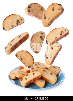 Sweet hard chuck crackers with raisins falling into plate on white background Stock Photo