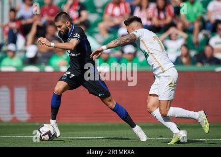 Elche, Spain. 14th May, 2023. Yannick Carrasco (L) of Atletico de Madrid vies with Josan Fernandez of Elche during the Spanish La Liga football match between Elche CF and Atletico de Madrid in Elche, Spain, May 14, 2023. Credit: Str/Xinhua/Alamy Live News Stock Photo