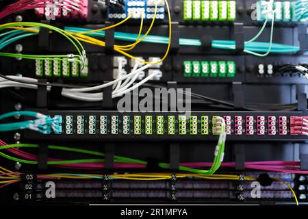 Fiber optic patch cords and rack mount patch panels. Fiber network distribution cabinet with passive optic equipment and cable management system. Sele Stock Photo