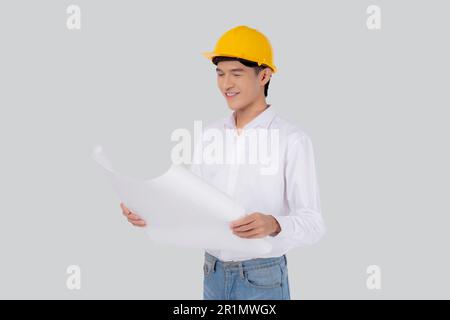 Portrait young asian man is engineer wearing helmet holding and looking blueprint with confident isolated on white background, handsome male is archit Stock Photo
