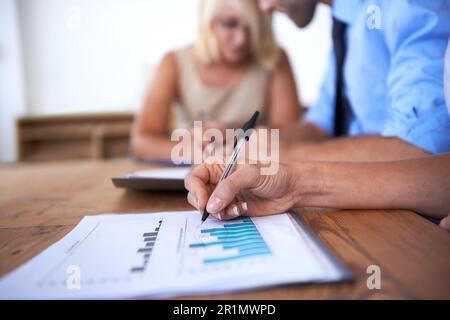 Going over the numbers. three businesspeople looking over some documents together. Stock Photo