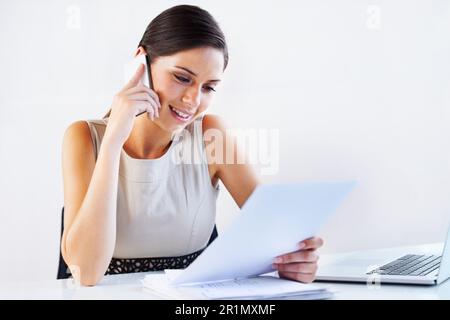 Working on some fine details. a young businesswoman working in an office. Stock Photo