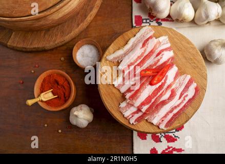 Traditional Ukrainian towel along with garlic, bread and salt. Top view of a wooden tray on a black background on which lies Ukrainian food with spice Stock Photo