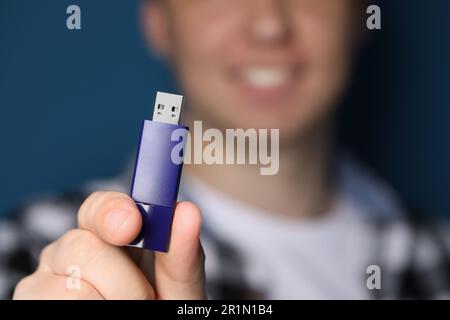 Man with usb flash drive on blue background, closeup. Space for text Stock Photo