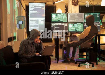 Two hackers working on computers to crack encryption Stock Photo